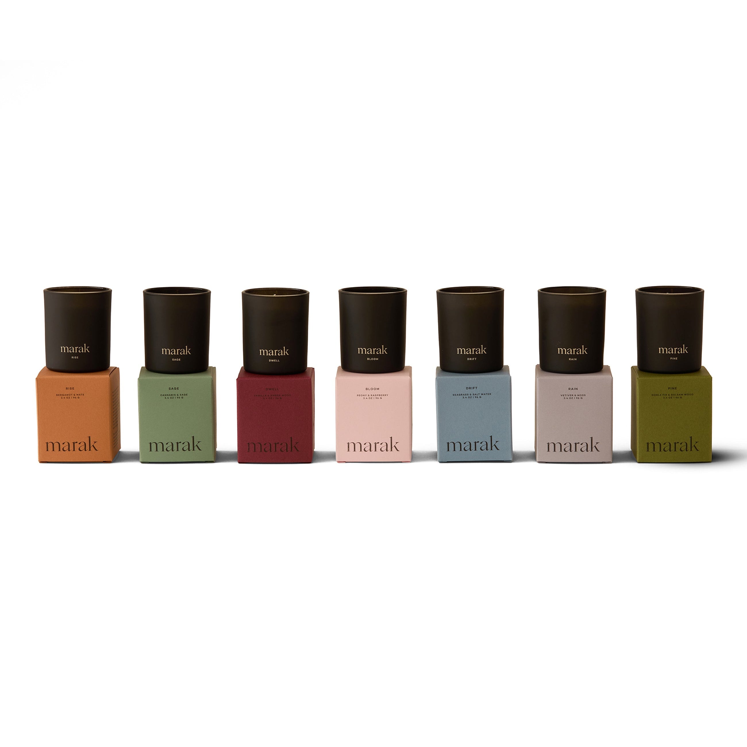 Marak scented candle gift set — 7 black glass votives in assorted colorful bases.